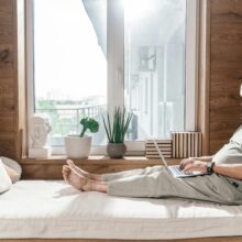 SENIOR WITH DISABILITY ON LAPTOP IN BED