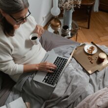 WOMAN ON COUCH WORKING ON LAPTOP