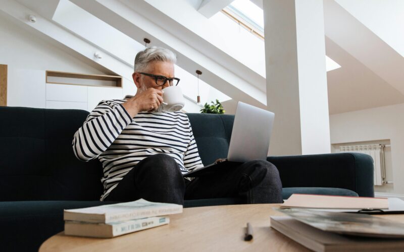 senior gentleman working on laptop at desk