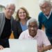 Four Seniors looking at a Laptop