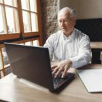 PIC OF sENIOR GENT ON LAPTOP IN HOME OFFICE