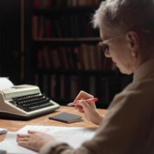 female senior working at desk writing ebook