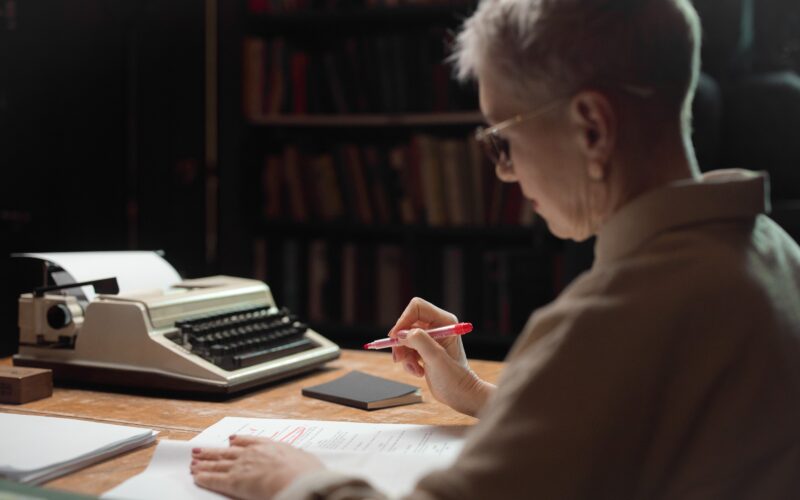 female senior working at desk writing ebook